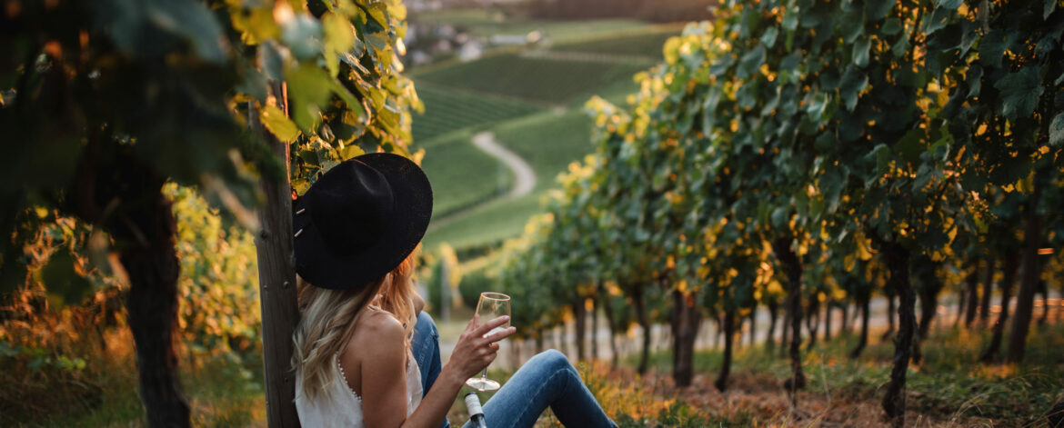 young blonde woman relaxing vineyards summer season with bottle wine scaled 1